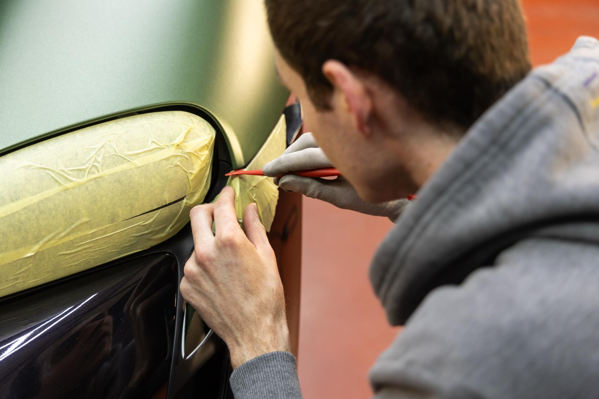 Man die een wagen aan het wrappen is.